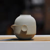 Round beige teapot with concentric circle design on wooden surface