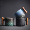 Group of black and teal ceramic mugs with handles