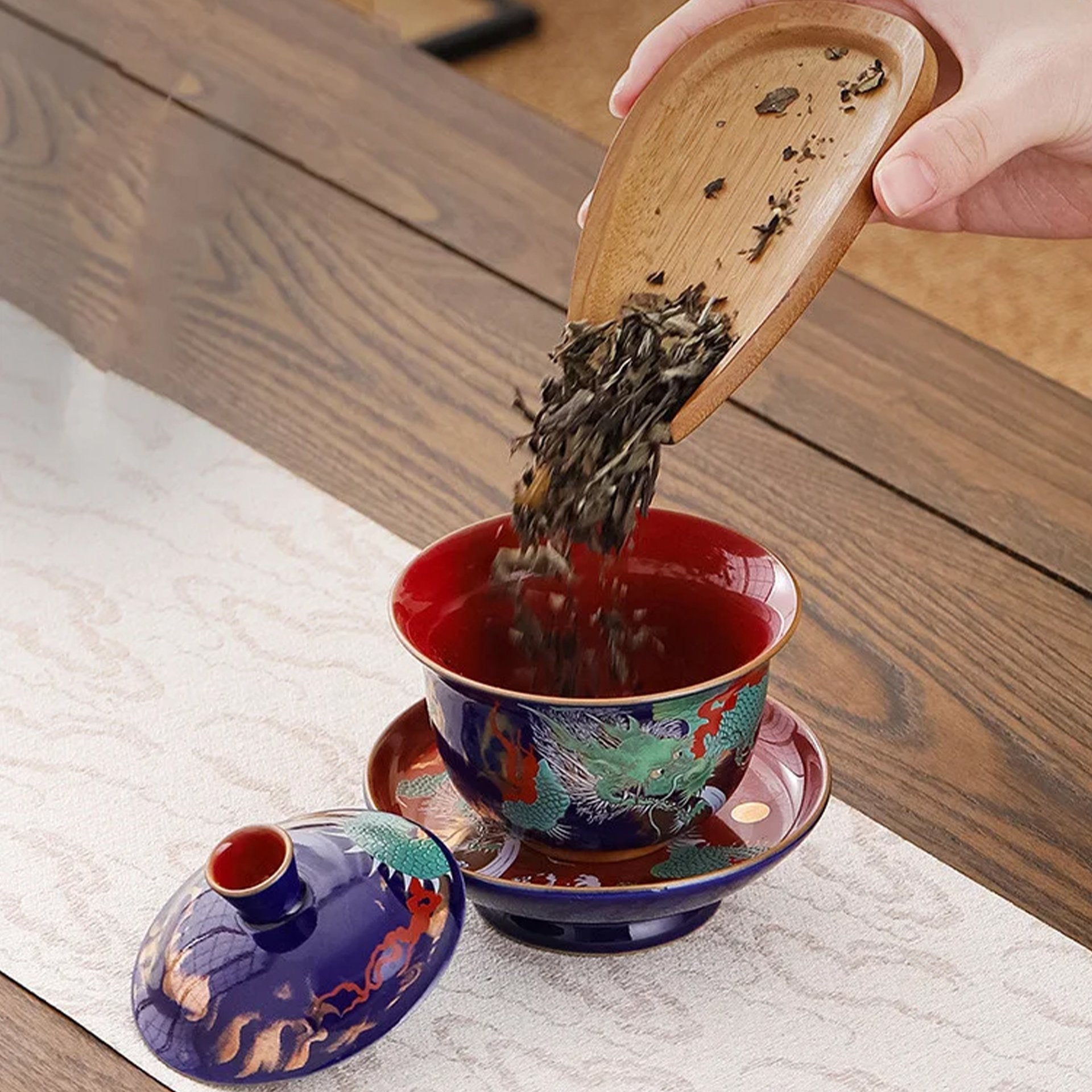 Loose tea being poured into a dragon gaiwan.
