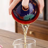 Pouring tea from a vibrant dragon-patterned teapot.