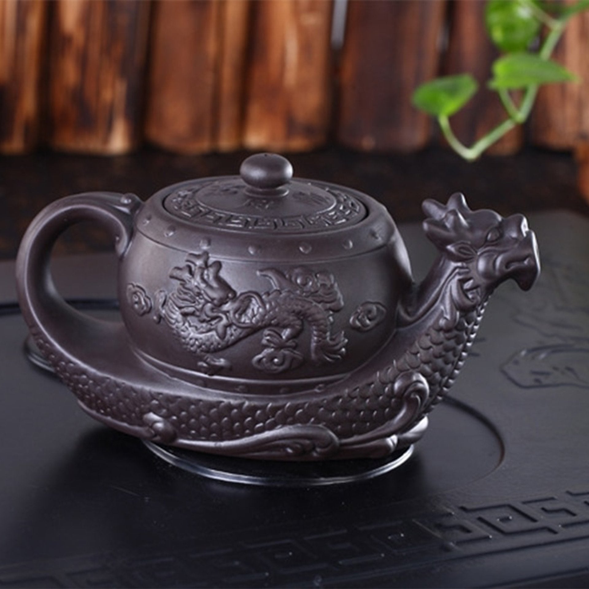 Full view of dark dragon teapot with intricate designs and robust handle.
