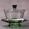Gaiwan-style glass teapot with green trim.