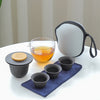 Compact travel tea set with gaiwan and cups on table.