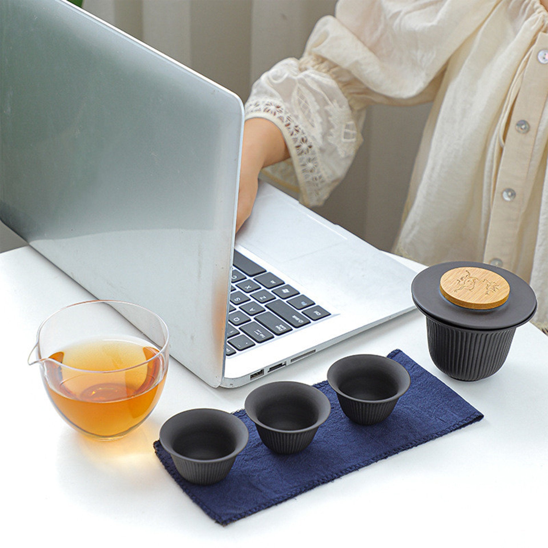 Tea set by a laptop on a desk, ready for a tea break.