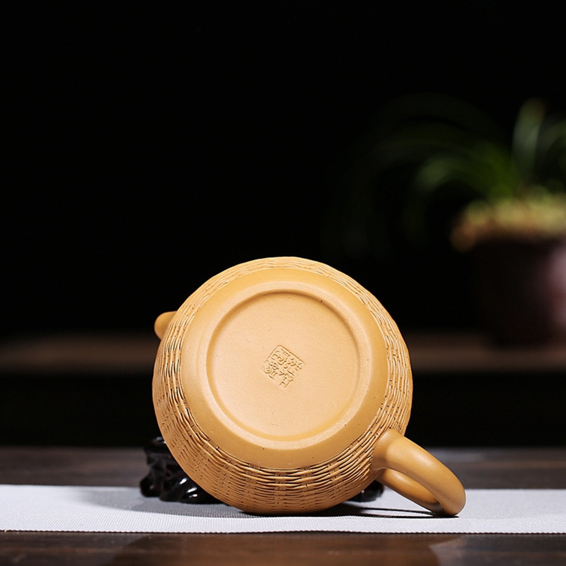 Bottom view of a golden textured teapot showing maker's mark.
