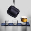 Travel tea set arranged on a gray surface with a black carrying case.