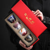 an open red gift box with four teacup