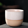 White and beige two-tone ceramic teacup with speckles.