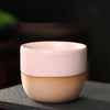 Pink and beige two-tone ceramic teacup with speckles.