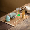 Matcha tea set with a whisk, bowl, scoop, and holder on a bamboo mat.