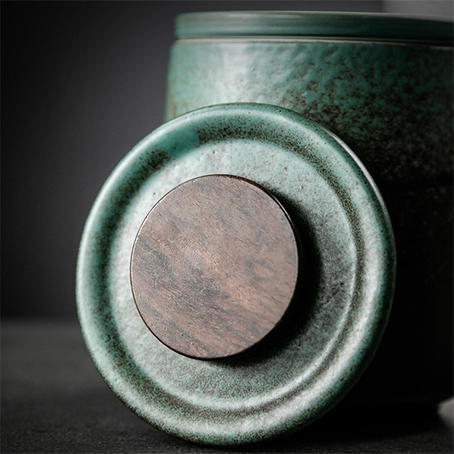 Close-up of tea mug's bottom showing its round wooden lid and textured base.