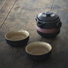 Dark textured ceramic teapot with relief patterns with two tea cups