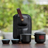 Travel tea set with black cups, pot, and black carrying case.