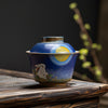 Rabbit adorned teapot on a bamboo mat, moon detail visible.