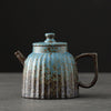 Textured stoneware teapot on a dark background, with a rustic aesthetic
