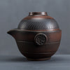 Textured brown clay teapot with Japanese character emblem on a grey background.