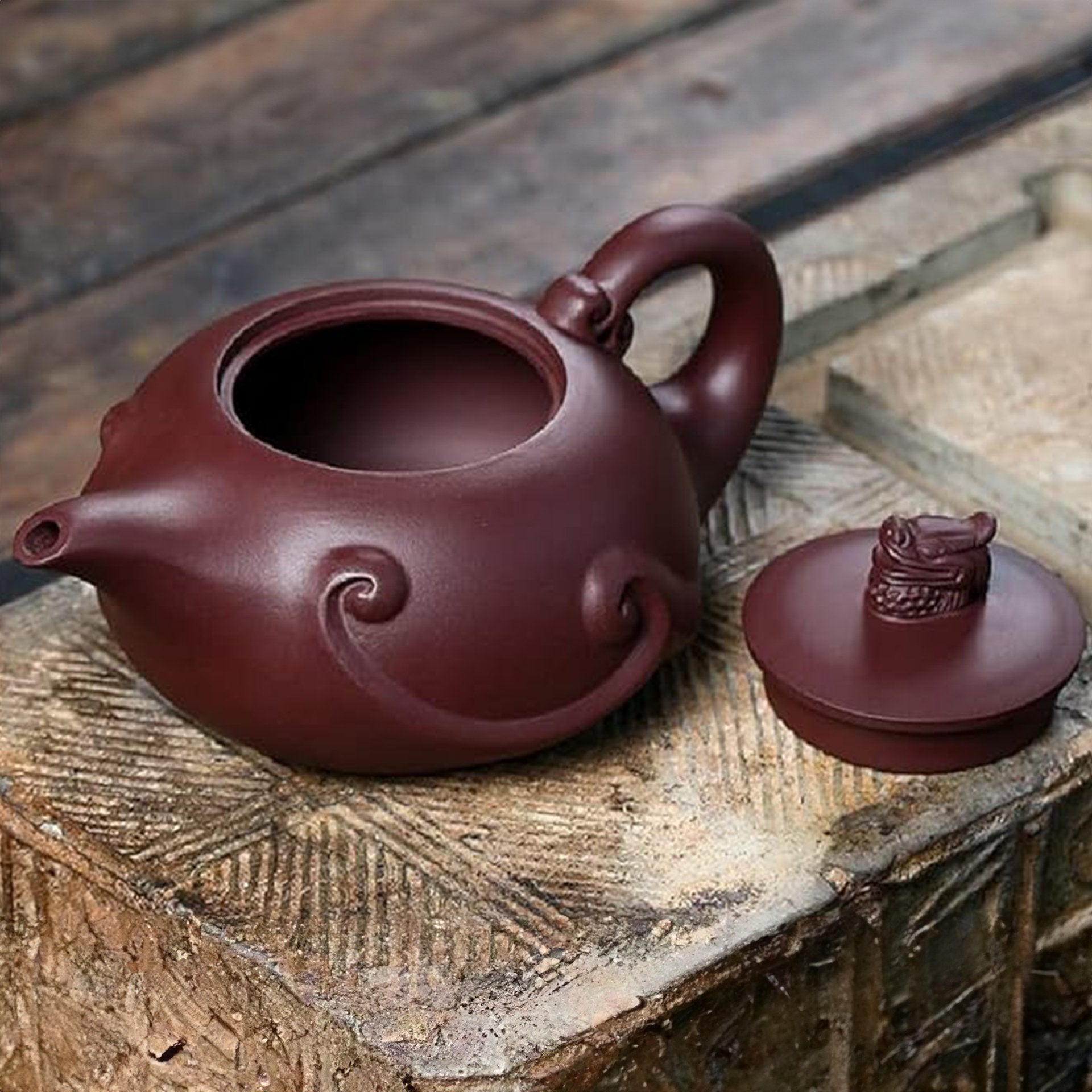 Close-up of a dark brown teapot with a dragon figurine on the lid.