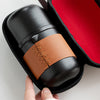 Black tea container with brown leather wrap in a zippered case with red interior