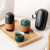 Tea set with leather-wrapped containers and cup on wooden tray and cream chair