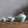 Celadon teapot and cups with dimensions and volume labeled against grey backdrop